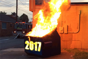 A dumpster on fire with the year 2017 on the front