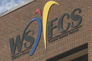Logo of Winston-Salem/Forsyth County Schools on the facade of an office building